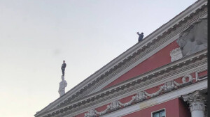 На Невском петербуржец залез на статую на крыше дома ради эффектного фото